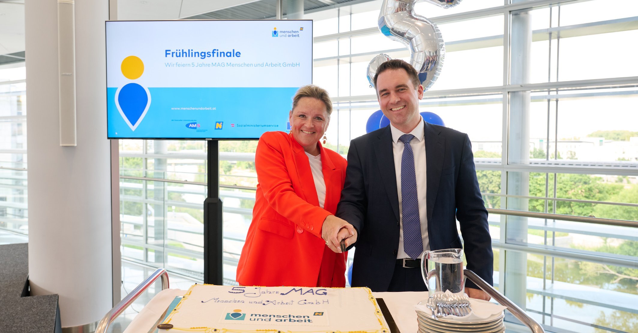 Landesrat Susanne Rosenkranz und Geschäftsführer der MAG Menschen und Arbeit GmbH Robert Lagler schneiden die Jubiläumstorte anlässlich 5 Jahre MAG an